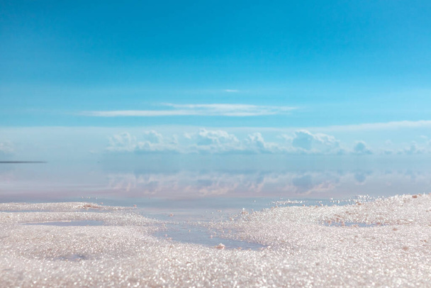 Кристали соляного піску закриваються на узбережжі озера з рожевою поверхнею води і відбиттям хмар і блакитного неба. Syvash or Sivash, the Putrid Sea or Rotten Sea, Ukraine - Фото, зображення