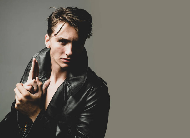 Sexy man with finger gun gesture isolated on grey background isolated. - Foto, imagen