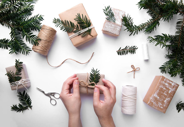 hands wrapping gifts for christmas holidays. next to threads and boxes - Zdjęcie, obraz