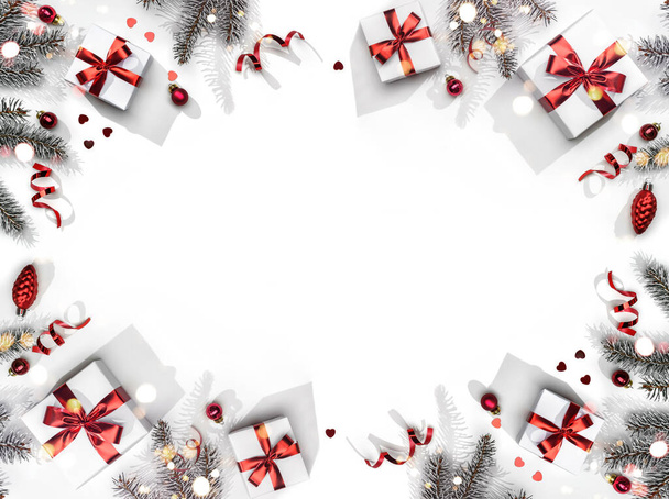 Veselé vánoční přání z jedlových větví, dárkových krabic, červené dekorace, jisker a konfet na bílém pozadí. Vánoce a Silvestrovské prázdniny, bokeh, světlo. Byt ležel, horní pohled - Fotografie, Obrázek