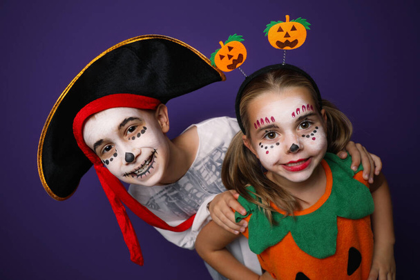 Cute little kids wearing Halloween costumes on purple background - Фото, изображение