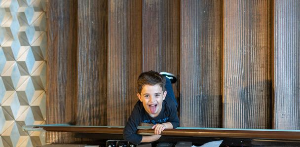 5 letý chlapec hraje na schodišti restaurace. - Fotografie, Obrázek