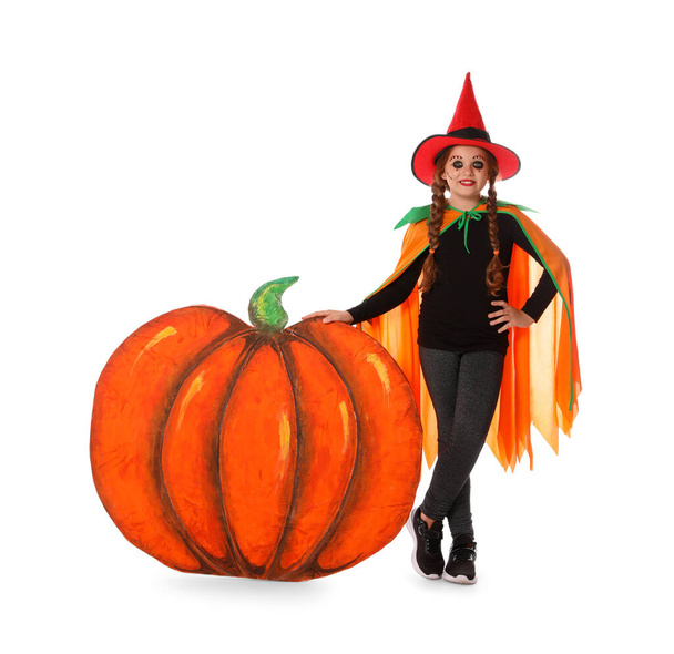 Cute little girl wearing Halloween costume and decorative pumpkin on white background - Zdjęcie, obraz