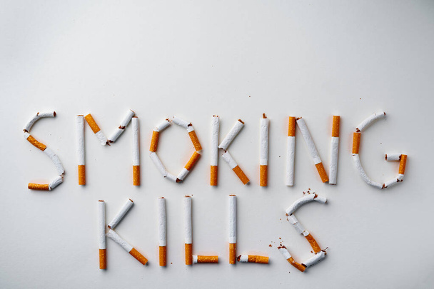 Inscription word SMOKIN KILLS made out of cigarettes top view - Photo, image