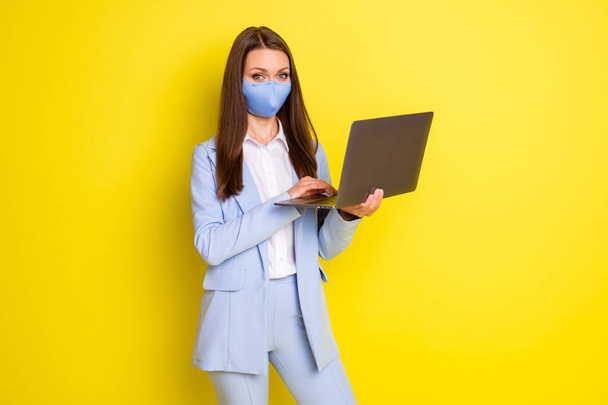 Photo of success company owner boss lady in respiratory mask work remote use laptop typing email wear blue jacket blazer pants trousers isolated over bright shine color background - Zdjęcie, obraz