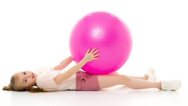 Little girl plays with a big ball for fitness - Valokuva, kuva