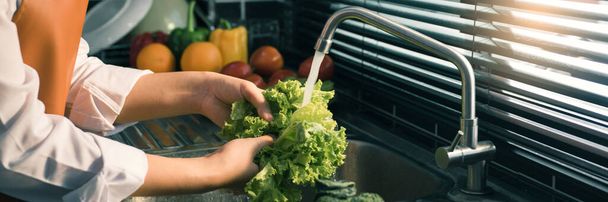 Aziatische handen vrouw wassen groenten salade en voorbereiding gezond voedsel in de keuken. - Foto, afbeelding