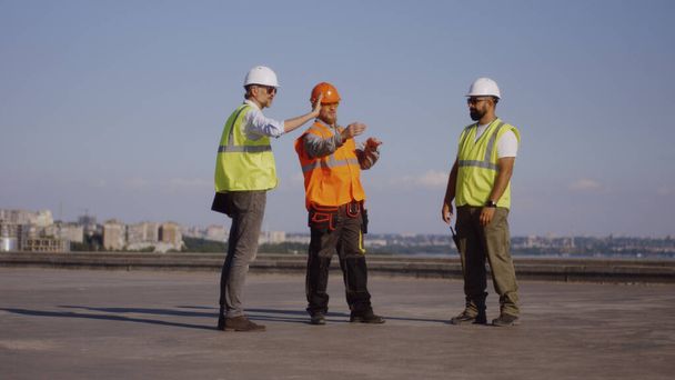 Constructeurs anonymes avec ordinateur portable sur le chantier de construction - Photo, image