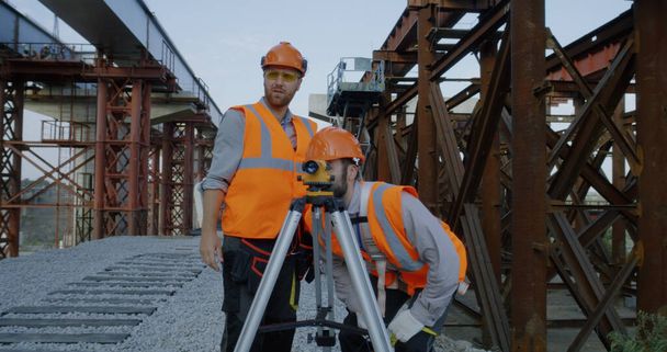 Surveyors measuring construction site with theodolite - Foto, Imagen