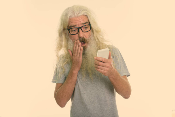 Studio záběr pohledný senior muž s dlouhou bílou kudrnaté vousy a vlasy izolované proti bílému pozadí - Fotografie, Obrázek