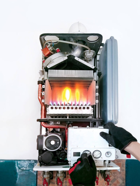 Verificação de caldeira a gás de circuito duplo com tampa aberta e fogo antes da temporada. Limpeza sistema de aquecimento de água quente. - Foto, Imagem