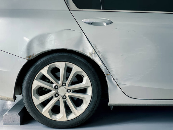 poškození karoserie po nehodě, poškrábání a promáčknutí karoserie moderního auta na parkovišti - Fotografie, Obrázek