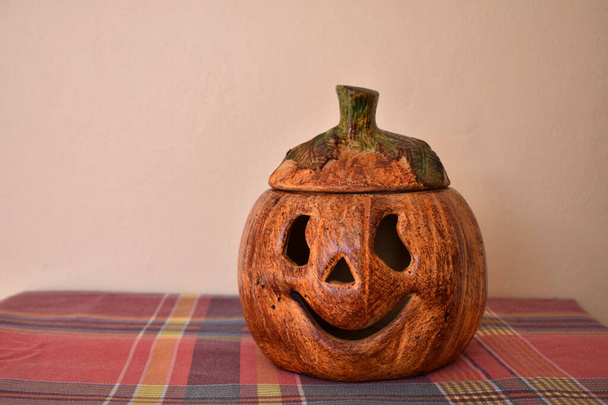 Keramische pompoen voor Halloween decoratie, glimlachen op een tafel - Foto, afbeelding