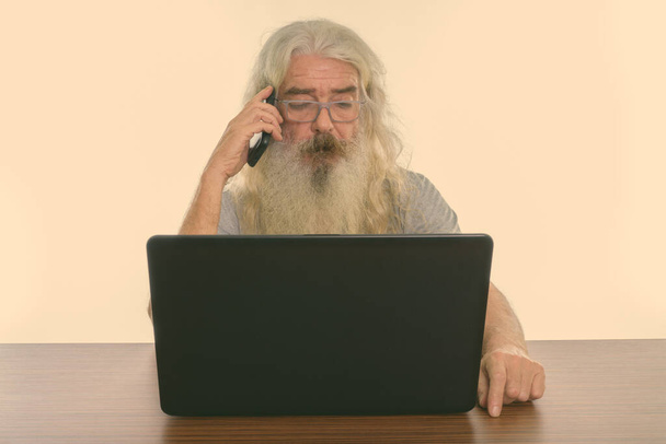 Uzun beyaz kıvırcık sakallı ve beyaz arka planda izole olmuş yakışıklı yaşlı adamın stüdyo fotoğrafı. - Fotoğraf, Görsel