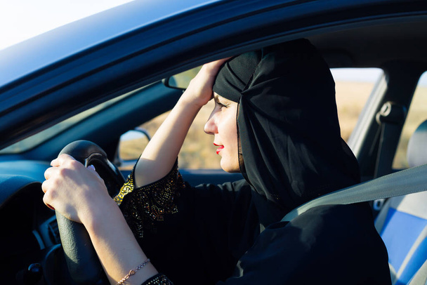 Tired islamic woman in traffic jam sitting behind the wheel. - Foto, immagini