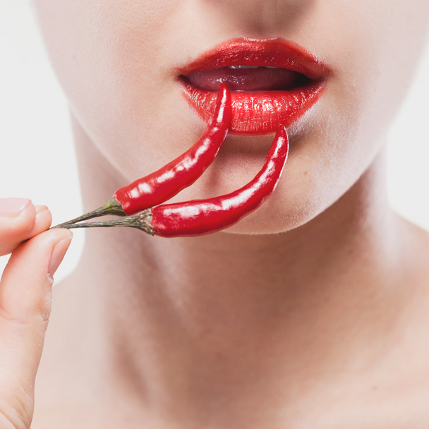 Young woman with chili pepper isolated on white - Фото, изображение
