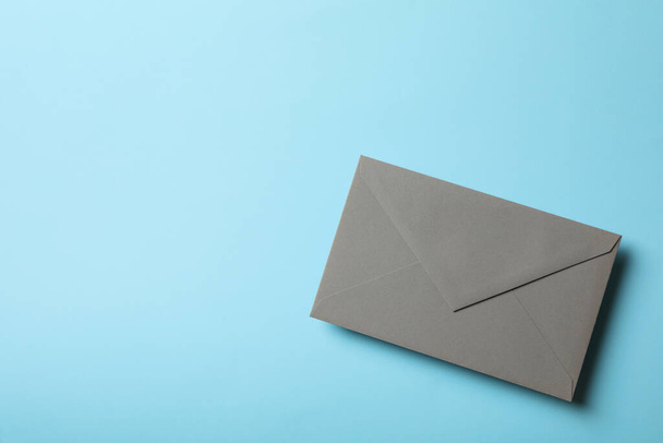 Gray envelope on blue background, space for text - Fotoğraf, Görsel