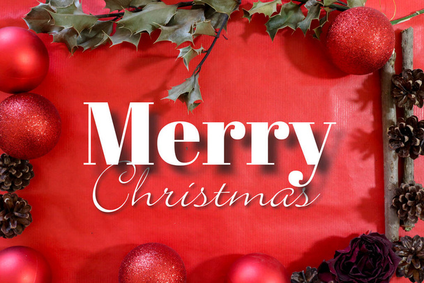 Composition d'un cadre avec divers objets décoratifs de Noël sur une carte cadeau de fond rouge avec l'inscription Joyeux Noël, vacances de Noël - Photo, image