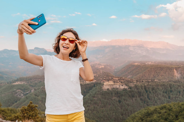 female travel blogger and social media influencer takes photos against the backdrop of the Taurus mountains in Turkey - Photo, Image