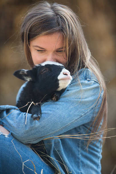 Young beautiful woman holding a small lamb - Foto, immagini