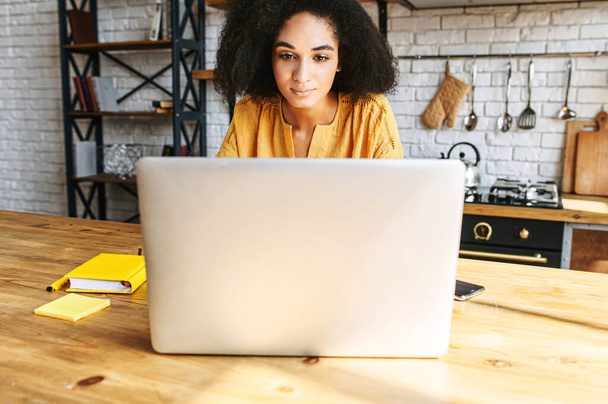 An african-american young woman is using laptop - Foto, Bild