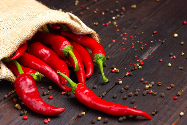 Red hot pepper in a bag on a dark wooden table. Chili. - 写真・画像