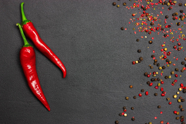 Red hot pepper chili on a black background with spices. Free place - 写真・画像