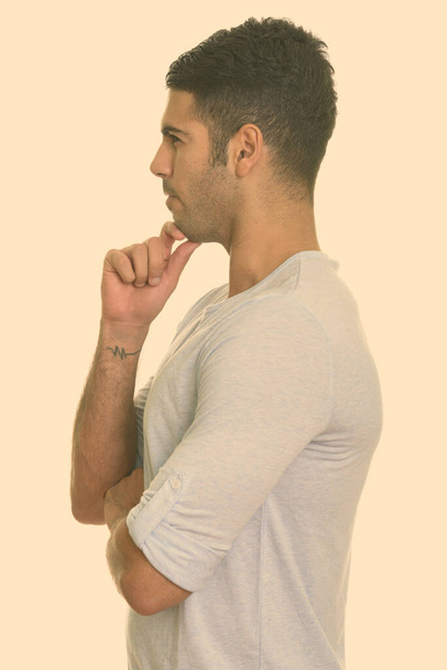 Portrait de jeune homme persan beau avec barbe chaume regardant macho isolé sur fond blanc - Photo, image
