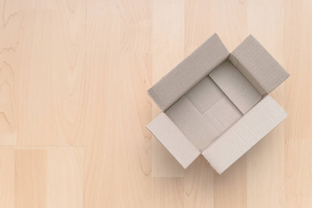 Κενό ορθογώνιο κουτί από χαρτόνι σε ξύλο. Ψώνια σε απευθείας σύνδεση φόντο αντικείμενο. Αντικείμενο δεμάτων αποστολής. - Φωτογραφία, εικόνα