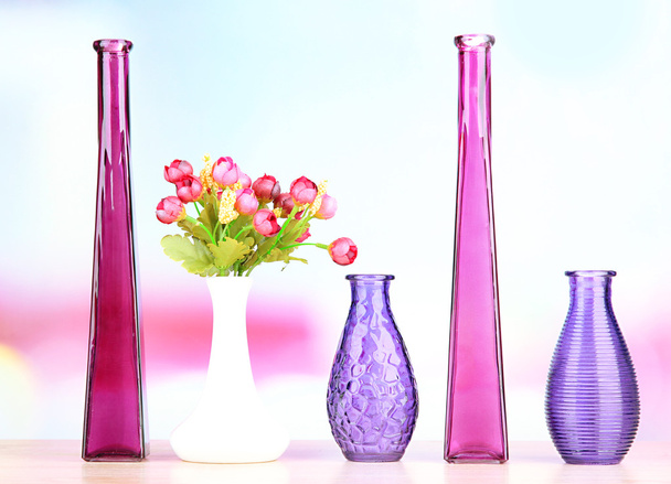 Different decorative vases on shelf on light background - Фото, изображение