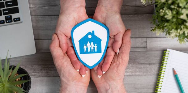Concepto de seguro familiar y de vivienda con escudo de papel en las manos - Foto, imagen