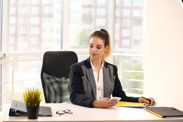 girl in a black businesswoman jacket works in a bright office - Zdjęcie, obraz