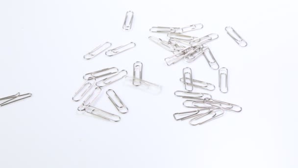 paper clips fall on the white table. school supplies. paper clips close up - Footage, Video