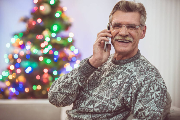 The happy old man phone near the christmas tree - Foto, Imagem