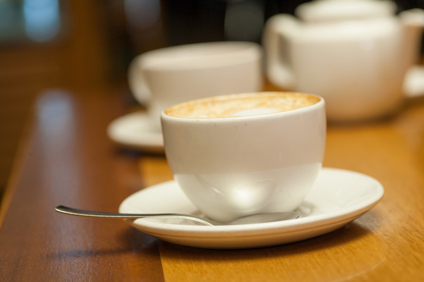 Cup of cappuccino on a table - Fotoğraf, Görsel