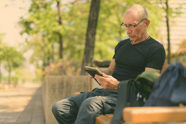 Porträt eines glatzköpfigen Touristenführers, der sich im Park im Freien entspannt - Foto, Bild
