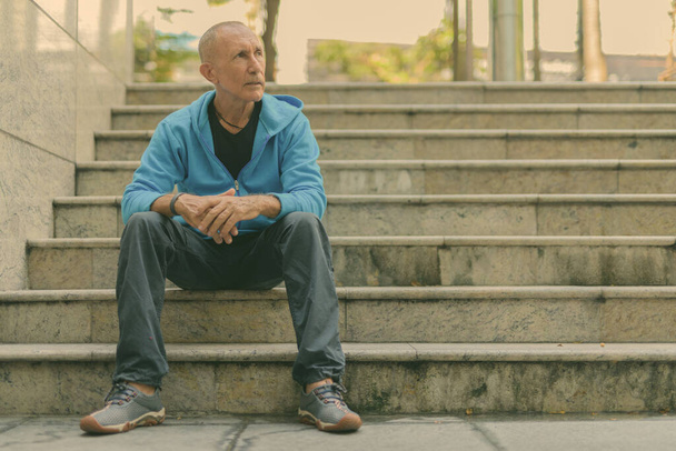 Portrait of bald senior tourist man in the city outdoors - Photo, Image