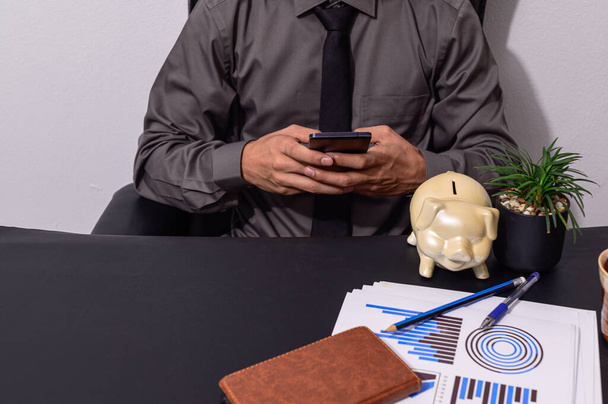  business man sitting at a desk using a smartphone - Photo, Image