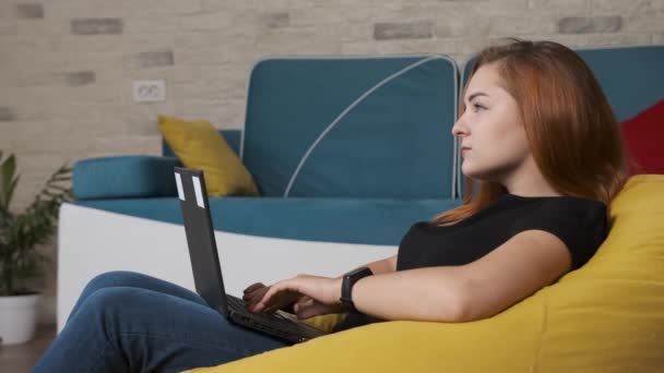 Egy fiatal nő a laptopnál dolgozik az otthoni irodából.. - Felvétel, videó