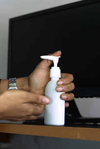 hygiene, health care and safety concept - indian woman using antibacterial hand sanitizer at home office - Zdjęcie, obraz