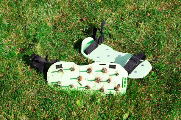 Sandaalit piikkejä ilmastus nurmikon maaperän ilmalla. Puutarhanhoito - Valokuva, kuva