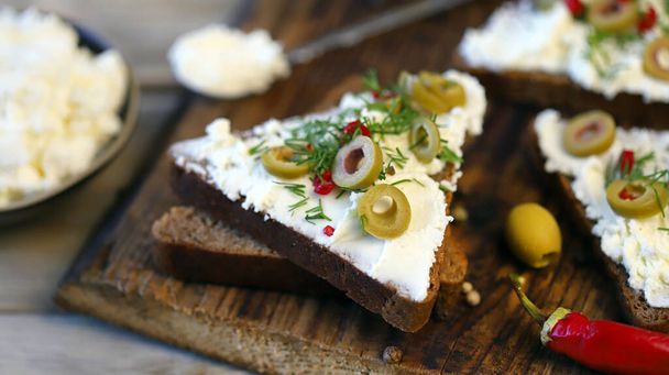 Sandwichs ouverts avec fromage mascarpone, olives et herbes. Une nourriture saine. Collation au céto. - Photo, image