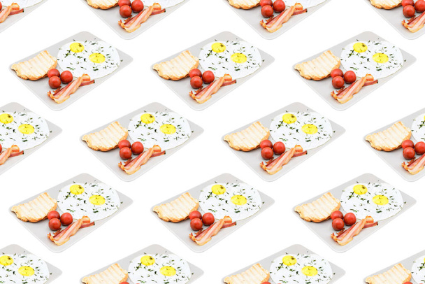 European breakfast with scrambled eggs, bacon and tomatoes with toast on a white tray. Seamless pattern - Zdjęcie, obraz
