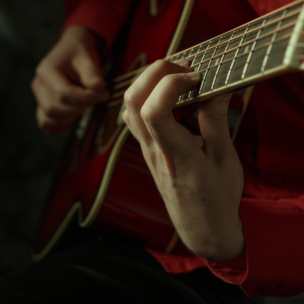 Гітарист грає на акустичній гітарі
 - Фото, зображення
