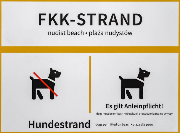 Çıplaklar plajı ve köpek plajı hakkında bilgi. İşaretteki tüm Almanca metinler de İngilizce ve Lehçe 'ye çevrilmiştir. Köpeklere izin verildiğinde ya da yasaklandığında kendi tarihinizi eklemek için yeriniz vardır.. - Fotoğraf, Görsel