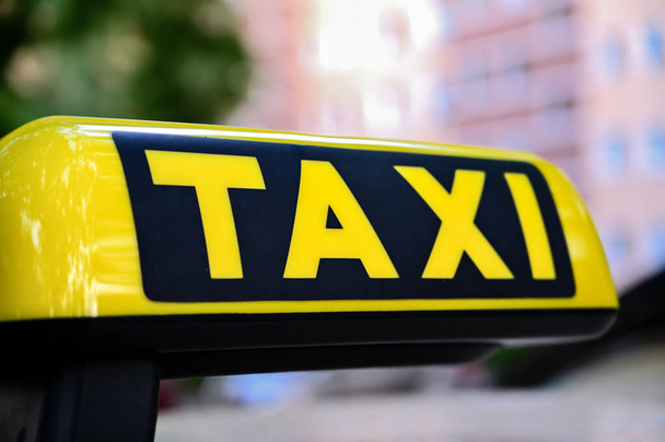 Sign with the lettering Taxi on a car roof with a blurred background that has space for text. - Photo, Image
