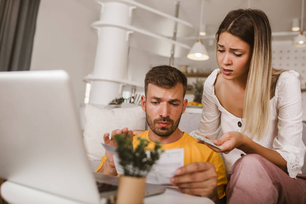 Portrait de jeune couple payant des factures en ligne à l'aide d'un ordinateur portable et carte de crédit.  - Photo, image