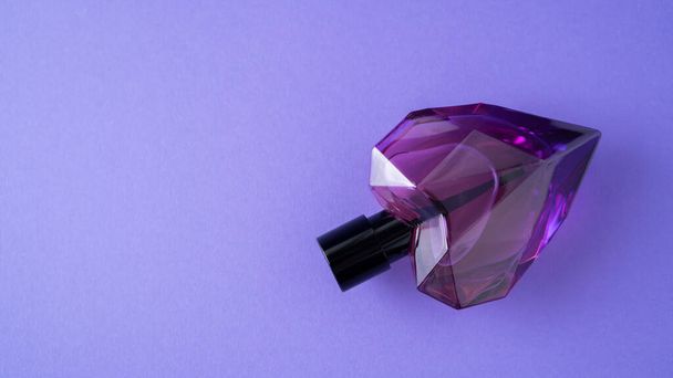 Izolált szív alakú parfüm palack lila alapon. Ajándék koncepció. Az illatspray gúnyolódik. Romantikus illat - Fotó, kép