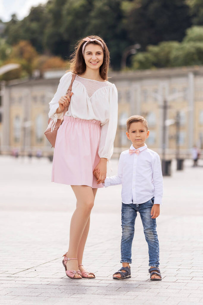 Jovem mãe alegre com filho em um passeio na cidade europeia. Menino sorrindo e se divertindo. Retrato de verão com espaço para texto. - Foto, Imagem