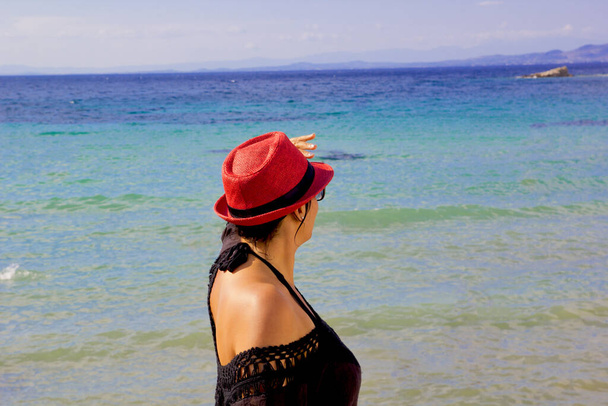 hermosa joven con un sombrero rojo en la playa - Foto, imagen
